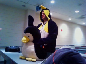 ram wearing a penguin suit with the LUUG's stuffed penguin.